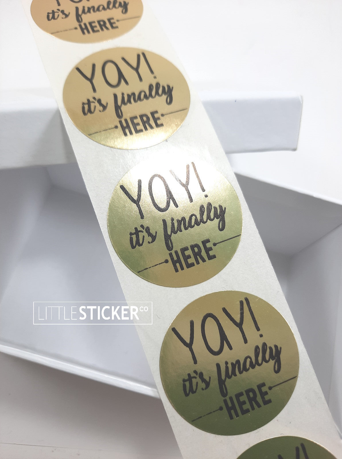 Little Sticker Co's metallic gold circle stickers. 40mm round with printed in black : ''Yay! it's finally here''.