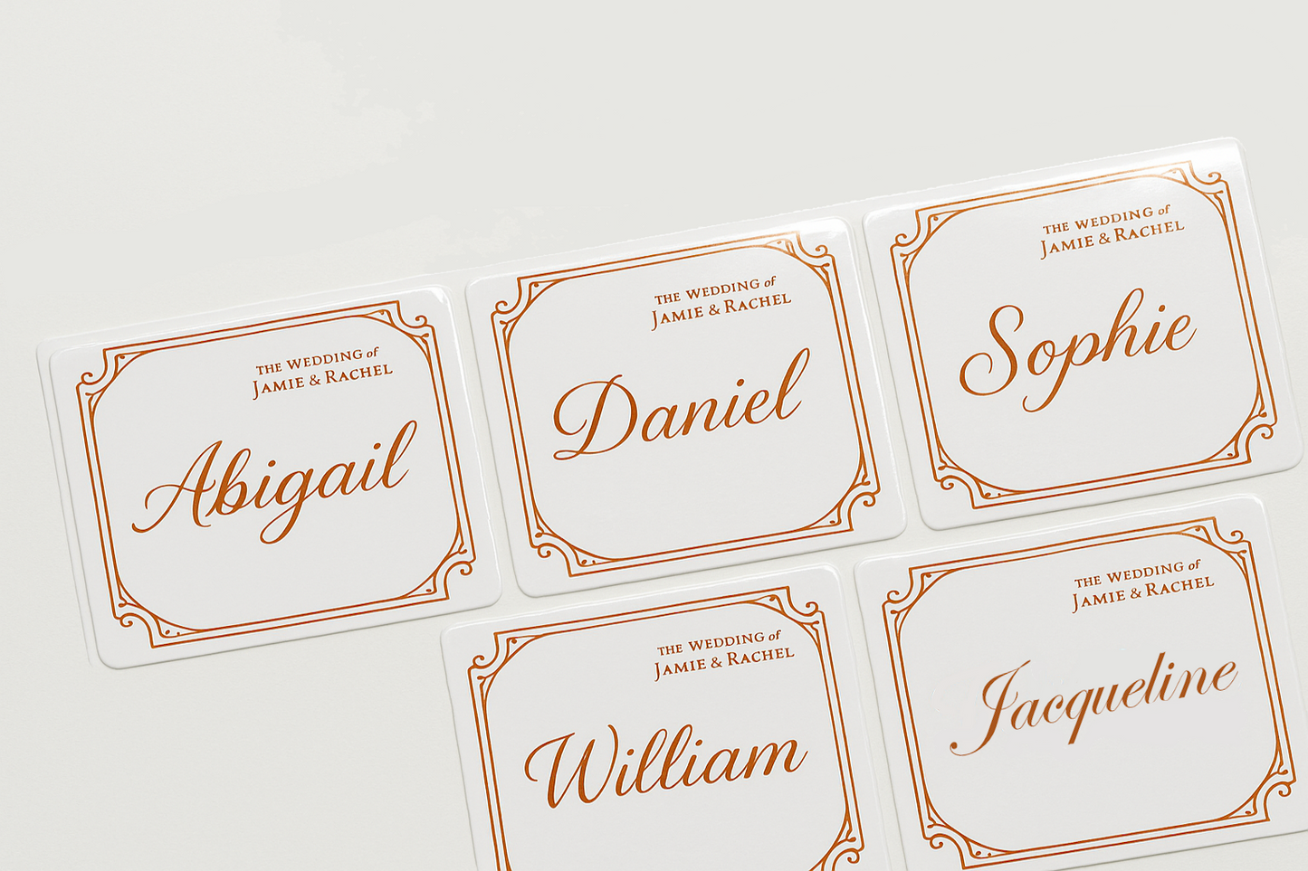 Set of personalized name stickers with orange text on a white background
