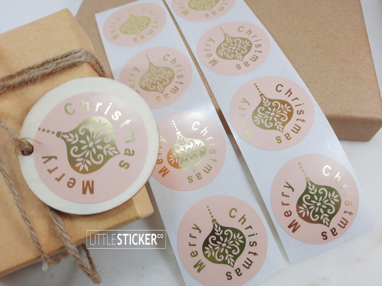 Merry Christmas stickers. 40mm round pink buff gloss stickers with Gold Foil ''Merry Christmas'' and Christmas bauble.