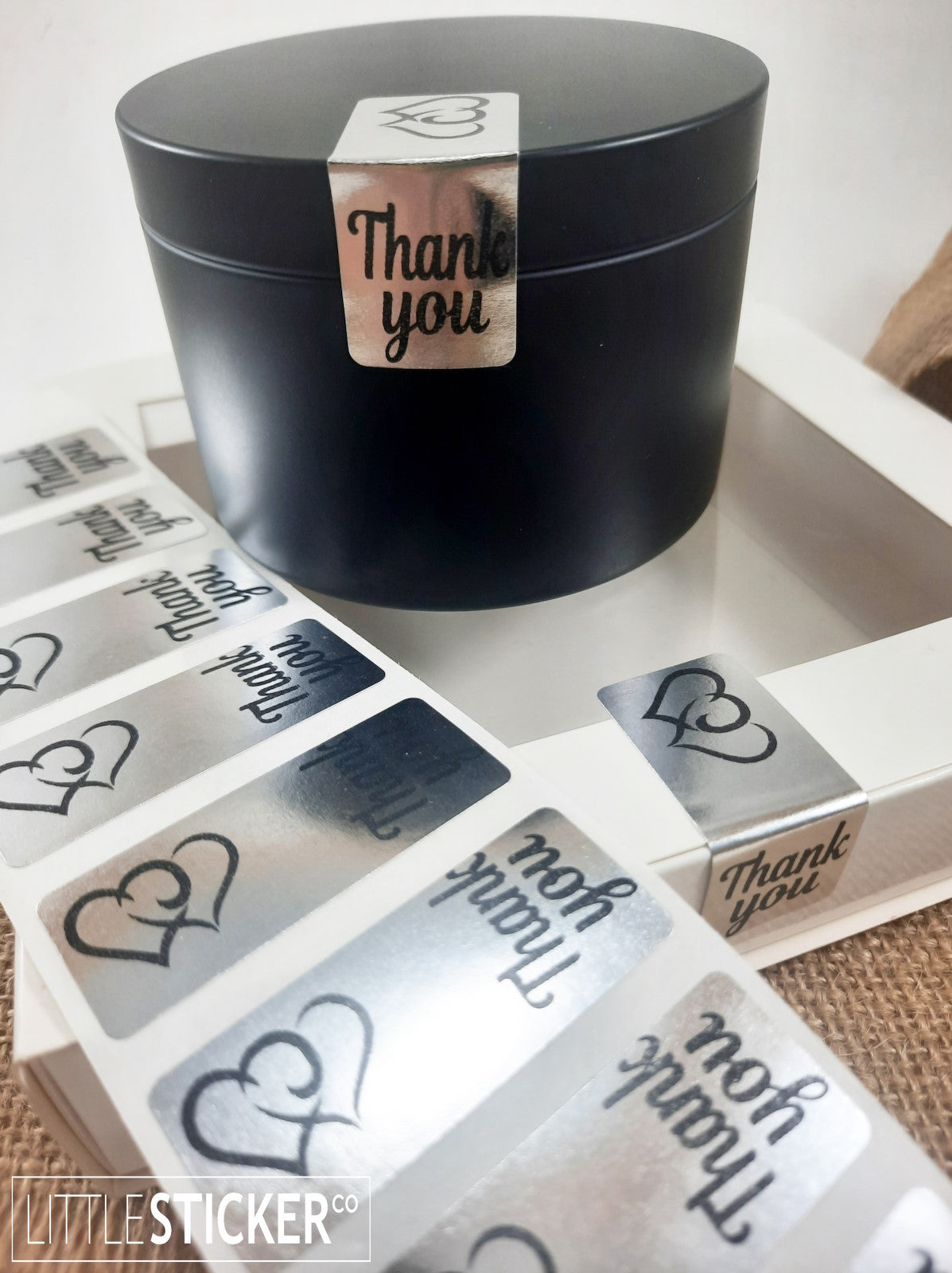 Thank you stickers. 50x20mm rectangle Silver stickers with black ''Thank you'' and twin hearts