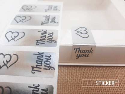 Thank you stickers. 50x20mm rectangle Silver stickers with black ''Thank you'' and twin hearts