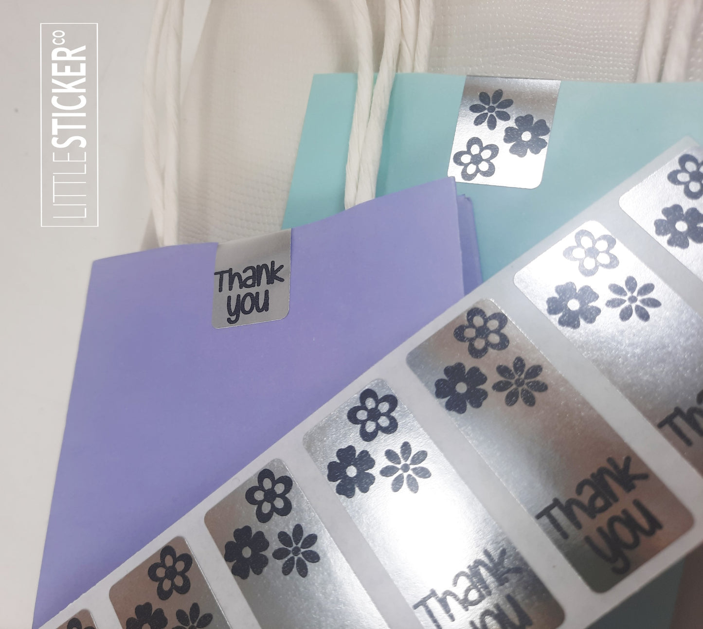 Thank you stickers. 50x20mm rectangle Silver stickers with black ''Thank you'' and cute daisy flowers