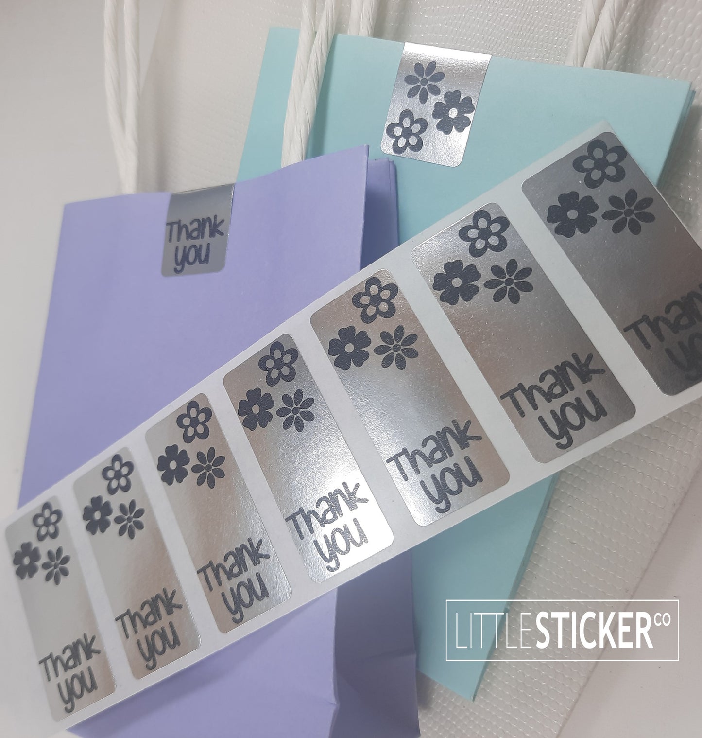 Thank you stickers. 50x20mm rectangle Silver stickers with black ''Thank you'' and cute daisy flowers