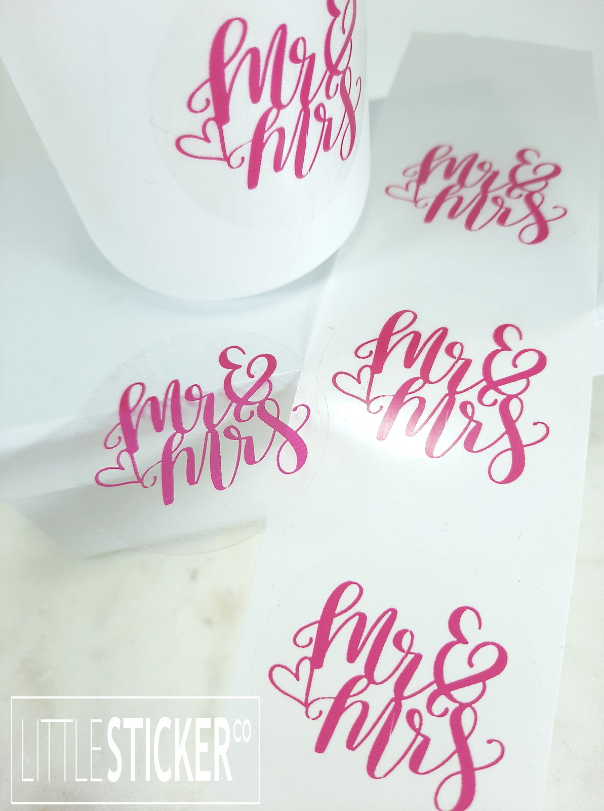 Mr & Mrs stickers. 40mm round clear stickers with magenta ''Mr & Mrs'' with cute heart outline