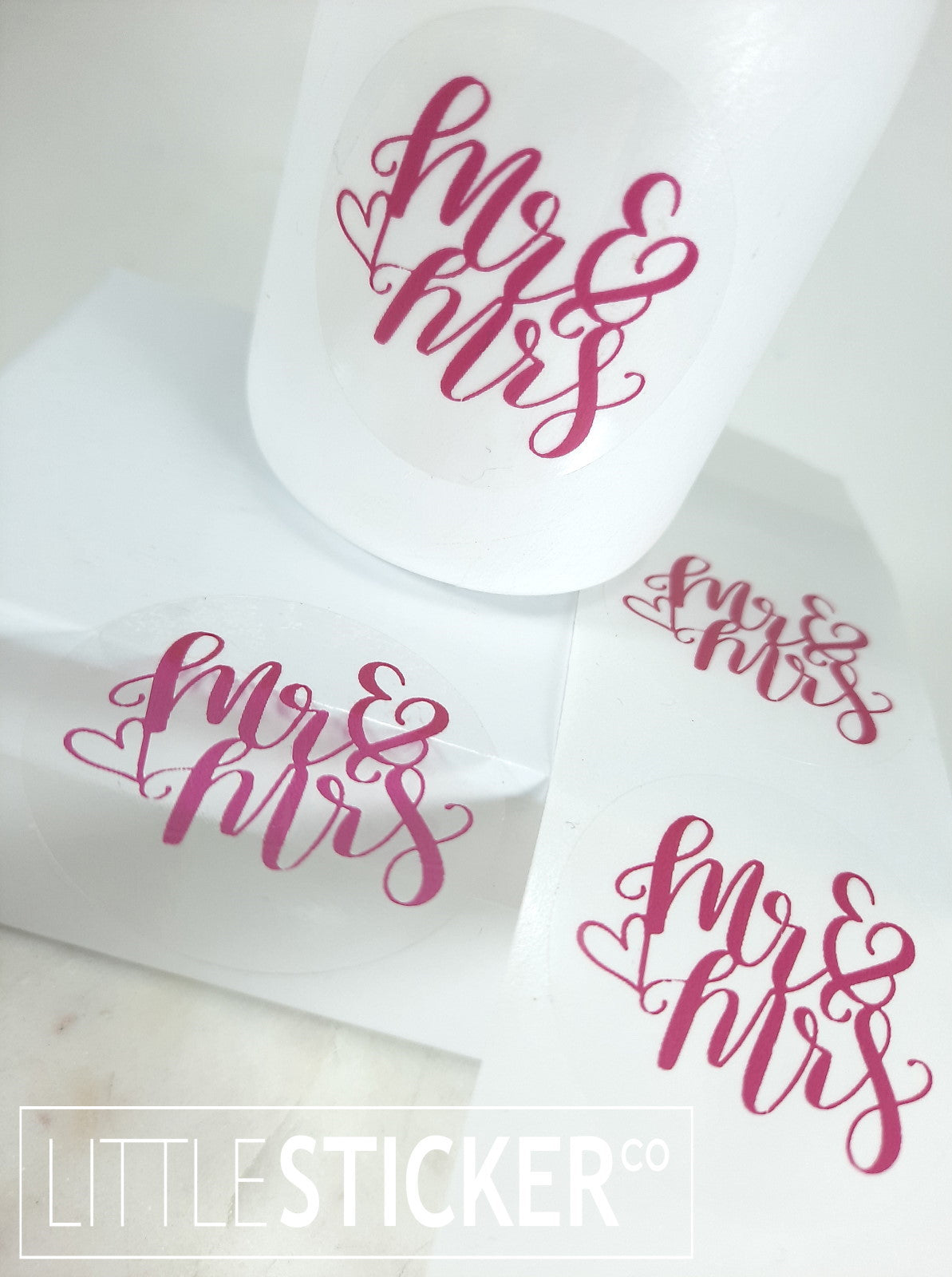 Mr & Mrs stickers. 40mm round clear stickers with magenta ''Mr & Mrs'' with cute heart outline