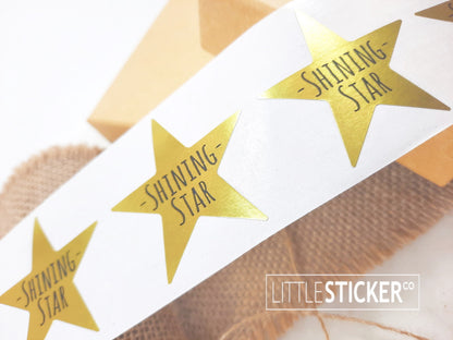 Award stickers or teacher stickers. 45mm metallic gold star shaped stickers printed with ''Shining Star''.