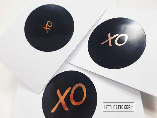 XO stickers  hand-drawn. Round gloss black stickers with rose-gold foil hugs and kisses symbol. Choice of small, medium or large print  XO