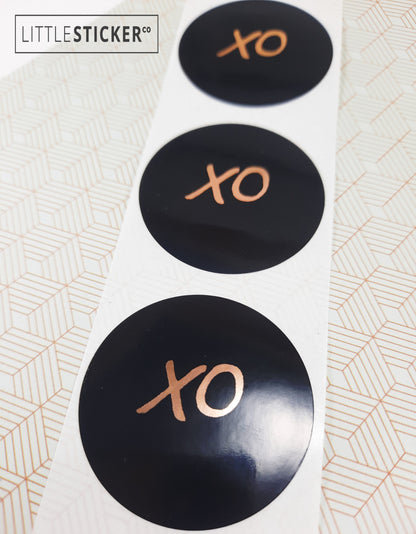 XO stickers  hand-drawn. Round gloss black stickers with rose-gold foil hugs and kisses symbol. Choice of small, medium or large print  XO