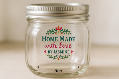 a photograph of a clear round sticker that is 5cm across. The sticker is stuck onto the front of a mason jar. The sticker has a pretty logo printed on it in multiple colours, with the text ''Home Made with Love by Jasmine''