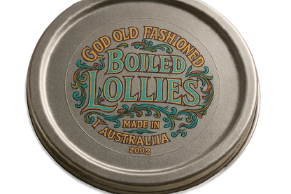 a photograph of a clear round sticker that is 5cm across. The sticker is stuck onto the lid of a round tin.  The sticker has an art nouveau style logo printed on it in multiple colours, with the text ''Good Old Fashioned Boiled Lollies. Made in Australia 200g''. The sticker is clear.