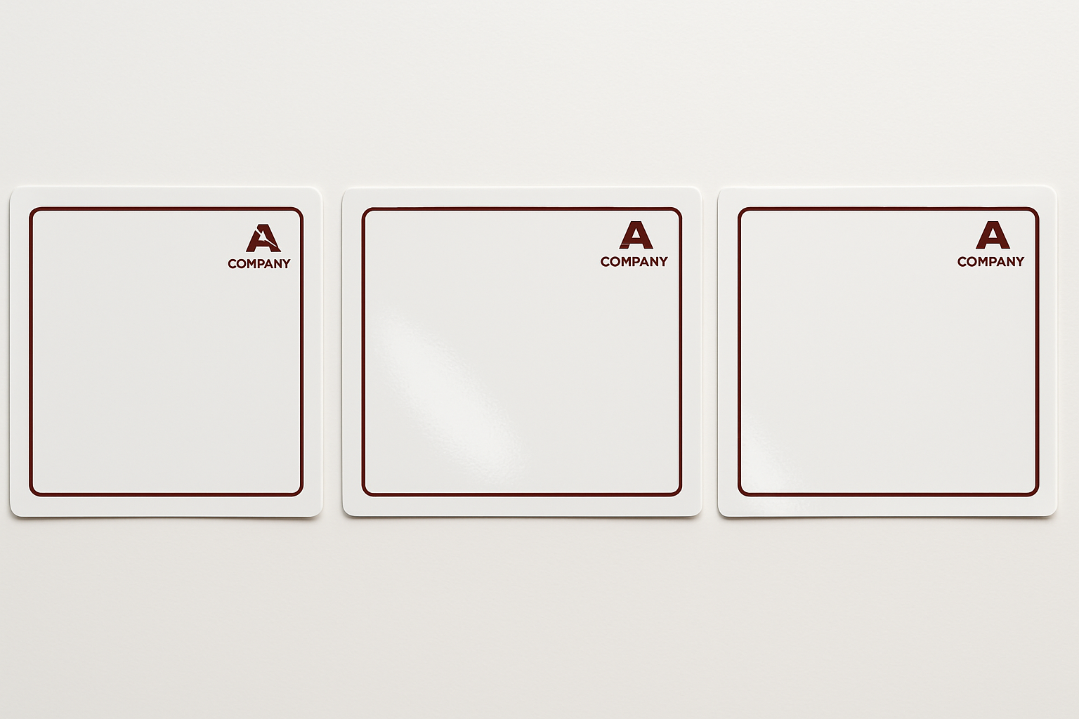 A row of glossy white stickers measuring 7cm wide and 6cm tall. The are facing in a landscape direction. Each sticker is printed with a dark red minimalist border. Each sticker has a small company logo in the top right corner in the same dark red colour